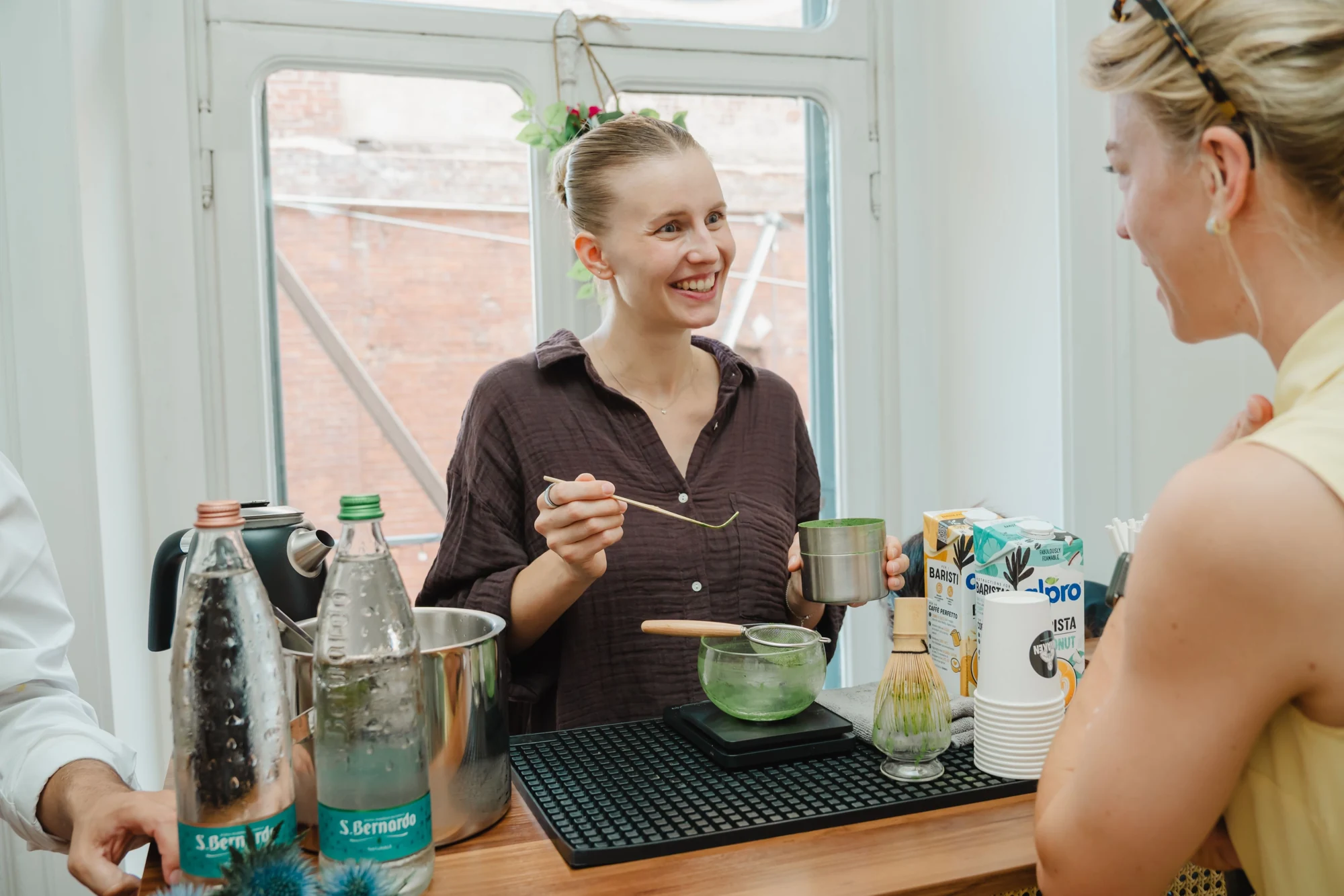 A host shares a matcha preparation with a guest at Il Salotto